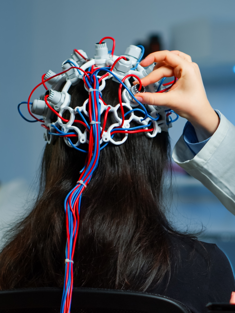 Patient undergoing EEG monitoring for epilepsy treatment with brainwave testing equipment and neurological evaluation in a clinical setting.